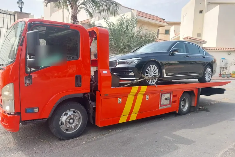 سطحة هيدروليكية تحمل سيارة سيدان فاخرة