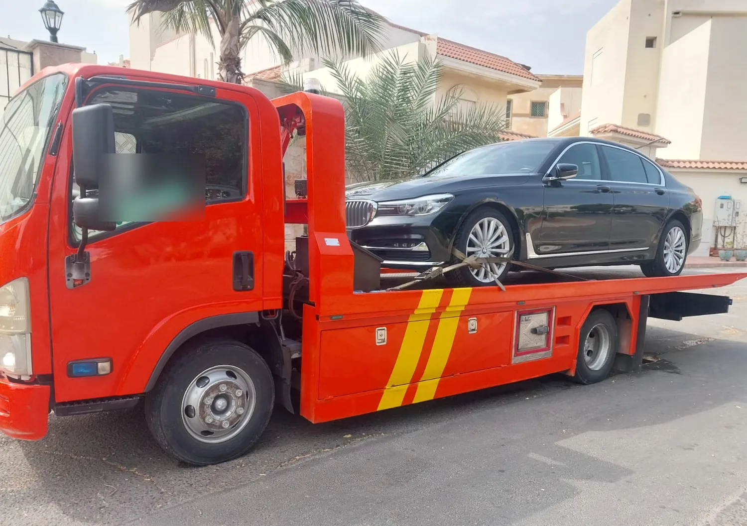 سطحة هيدروليك حمراء تحمل سيارة فاخرة